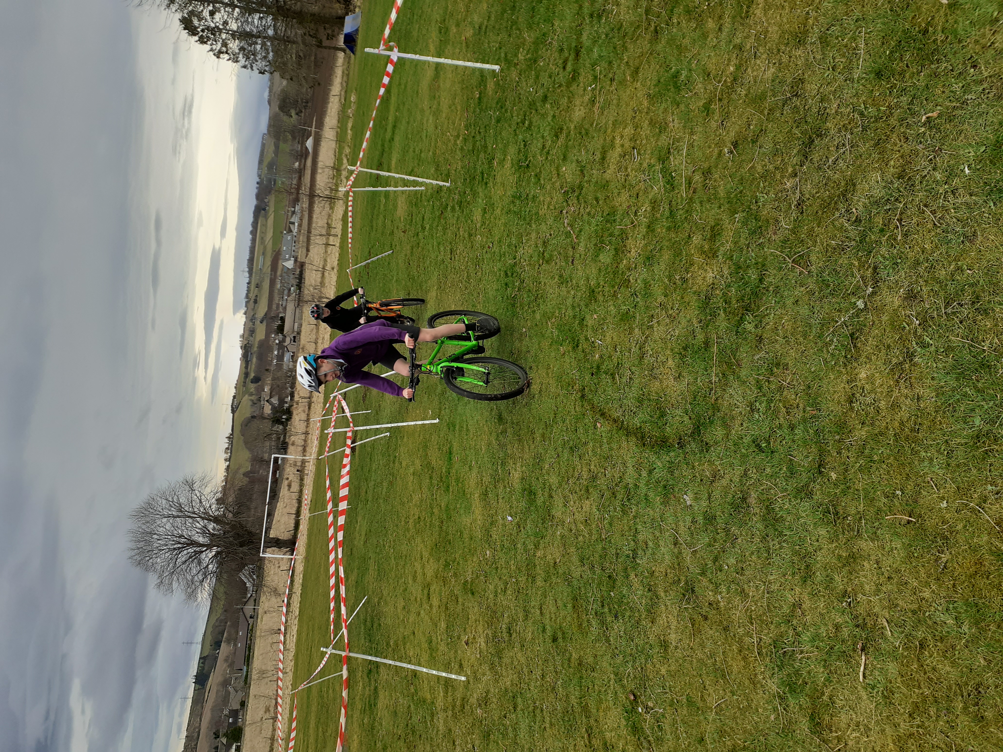 two young cyclists on a grass track