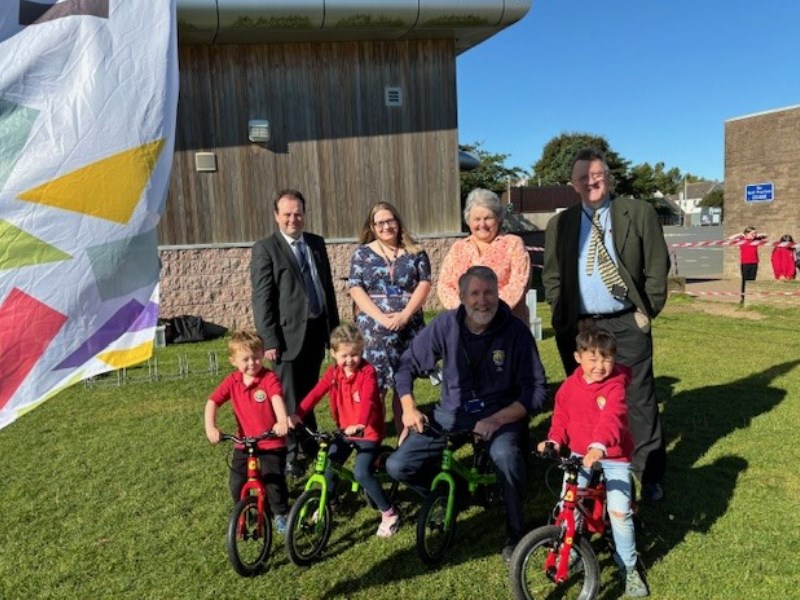 Local councillors with a group of children on their balance bikes 