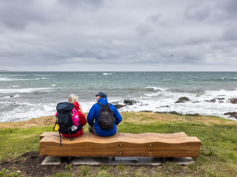 A couple of people sitting on one of the benches overlooking the sea in Peterhead