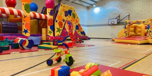 A sports hall set up with bouncy castles and soft play equipment