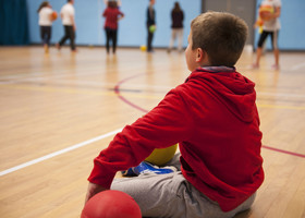 Image of a boy sitting down on a games hall floor