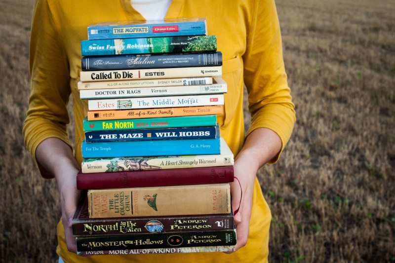 A person carrying a pile of books