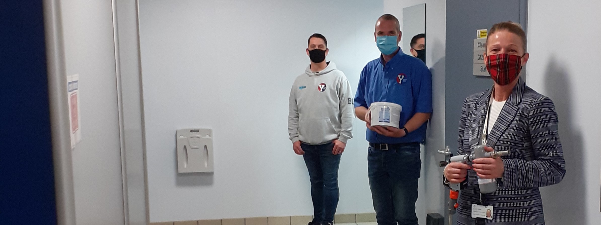 staff with donated sanitiser machine