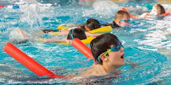 A group of children enjoying a swimming lesson