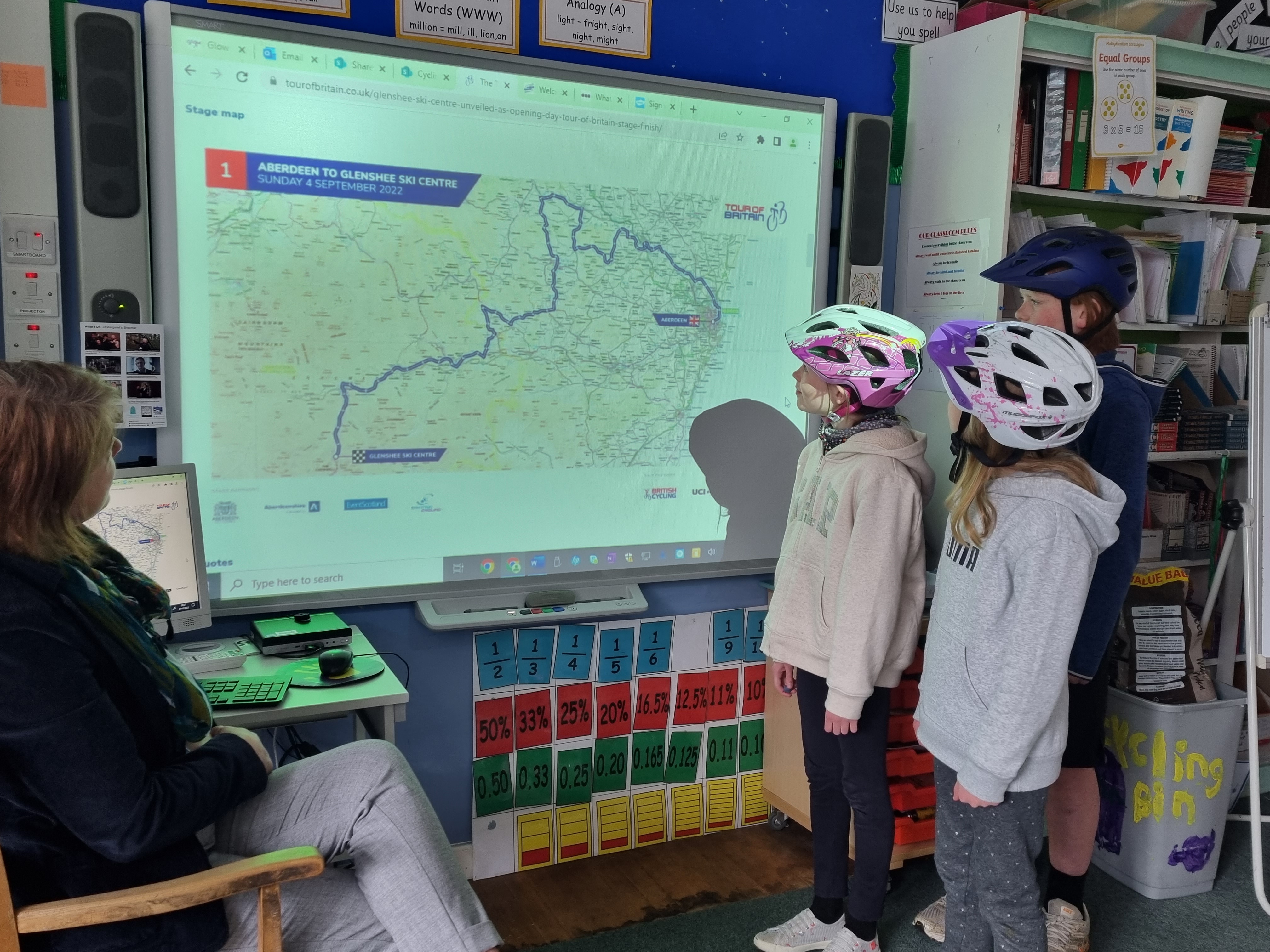 Braemar Primary School class teacher Mrs Nixon looks over Stage 1 of this year's Tour of Britain with pupils Eilidh, Chloe and Robin.