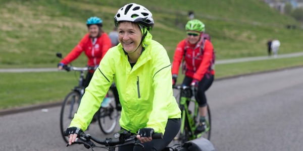 A woman enjoying a cycle outdoors with a group of friends