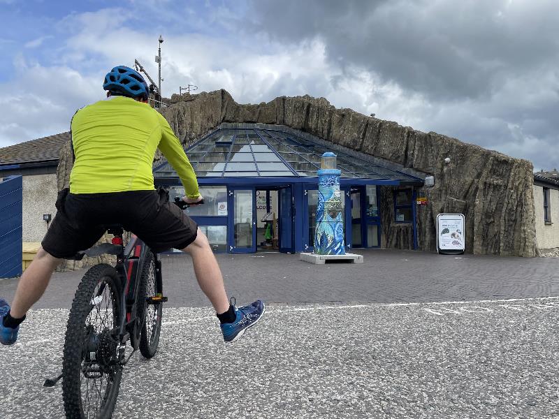 A person cycling to Macduff Marine Aquarium