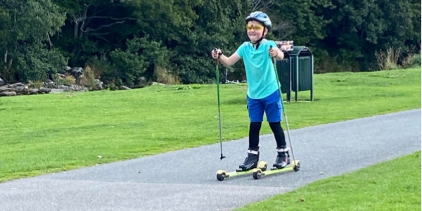 A child enjoying a roller ski lesson