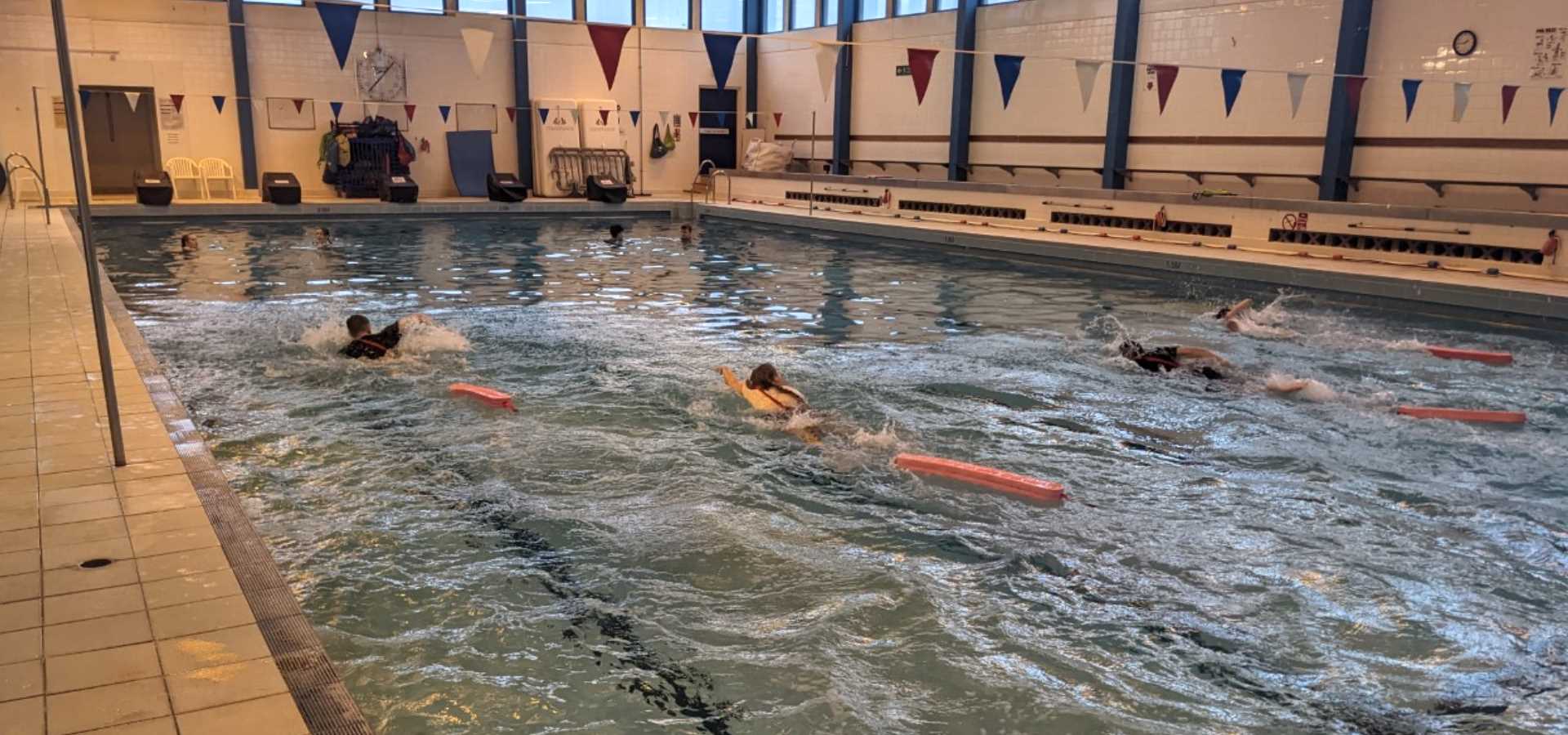 A group of senior pupils swimming lengths in the pool