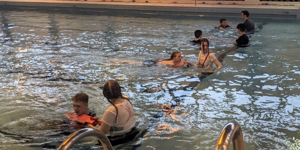 A groups of senior pupils practicing their life saving skills in the water