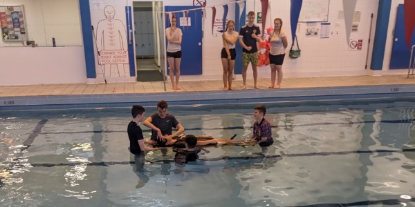 A group of senior pupils practicing their life saving skills in the water