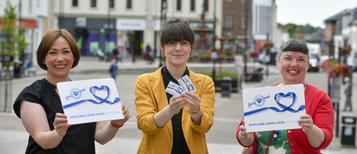 Photo of 3 women holding Love Local cards