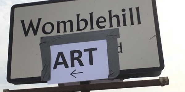 A sign with the words Womblehill Art