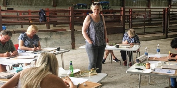 The artists working on their art pieces in a farm shed