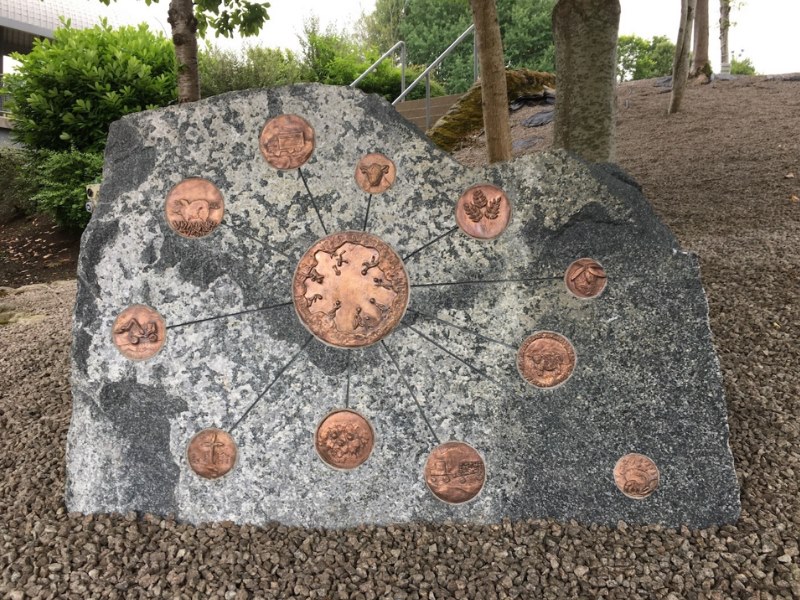 The stone sculpture with bronze medallions embedded into it