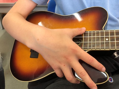 Primary school child playing a ukulele