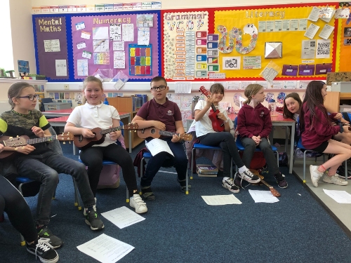 Group of primary school children holiding ukuleles