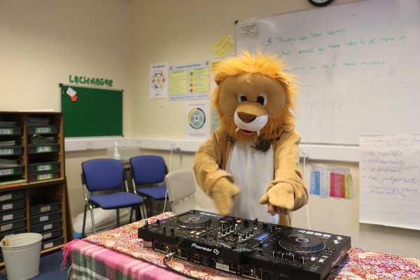 young person dressed in lion suit with DJ decks